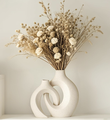 Een moderne vaas met gedroogde bloemen en takken in neutrale tinten.